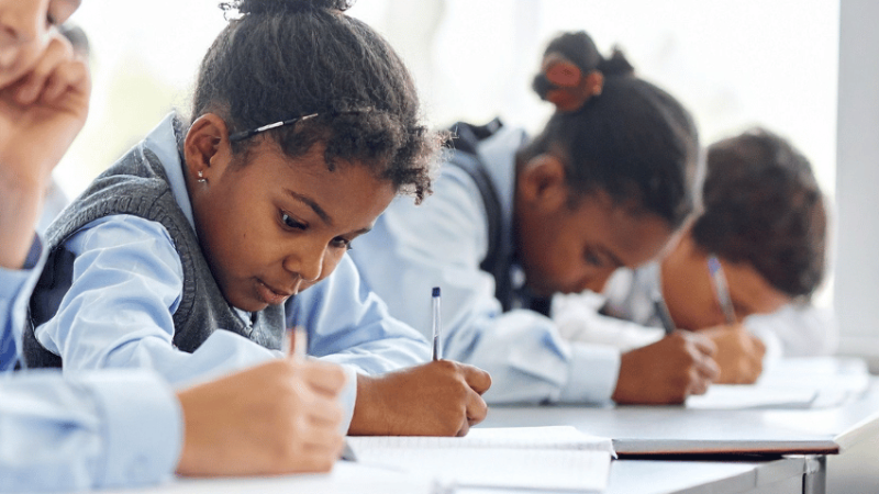 School pupils writing, representing dyslexia and processing information