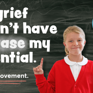 A school girl standing in front of a blackboard
