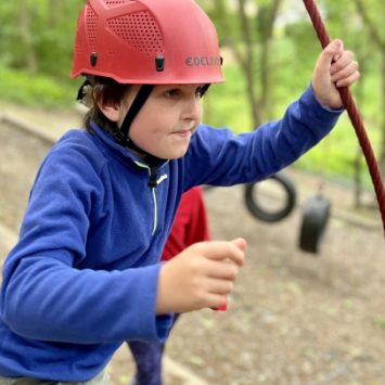 A boy on a ropes course at Boundless Outdoors