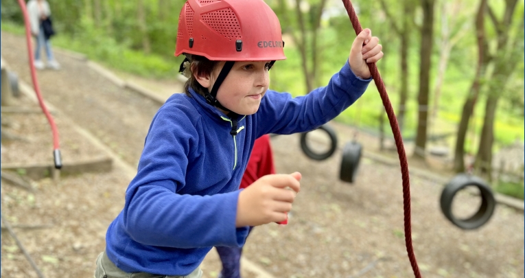 A boy on a ropes course at Boundless Outdoors
