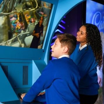 Two primary school children engaging with an interactive exhibit at Cadbury World