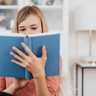 Girl reading book, representing writing for a purpose