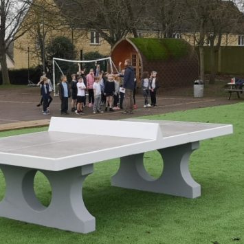 A playcrete table tennis table in a school field