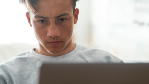 Teenage boy using AI to complete his homework