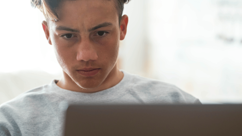 Teenage boy using AI to complete his homework