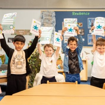 A group of primary school children holding Crest Award certificates