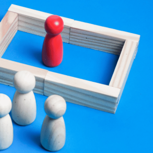 One wooden figure separated from others by a wall, representing audhd