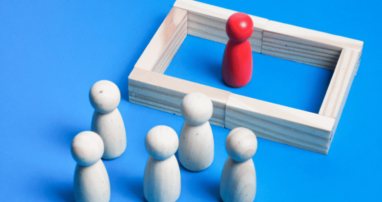 One wooden figure separated from others by a wall, representing audhd