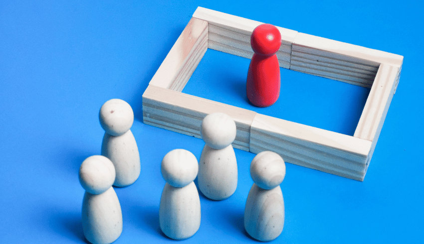 One wooden figure separated from others by a wall, representing audhd