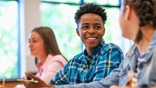 A smiling student sitting in a classroom