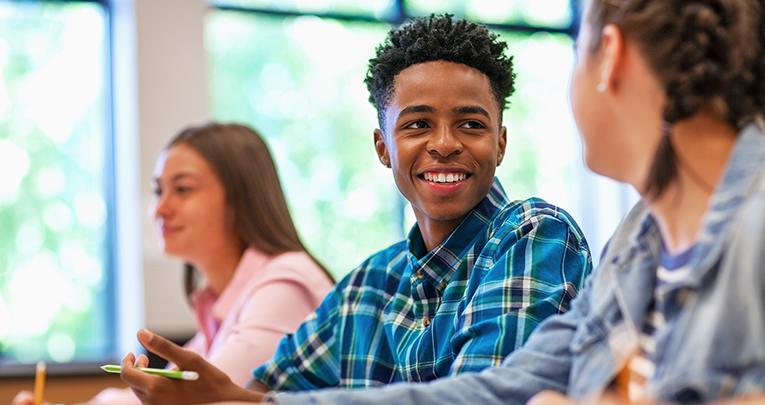 A smiling student sitting in a classroom