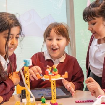 Three primary schoolgirls playing with LEGO