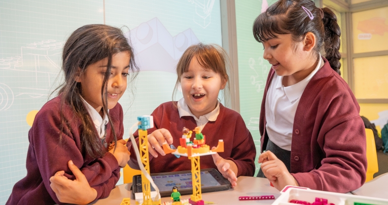 Three primary schoolgirls playing with LEGO