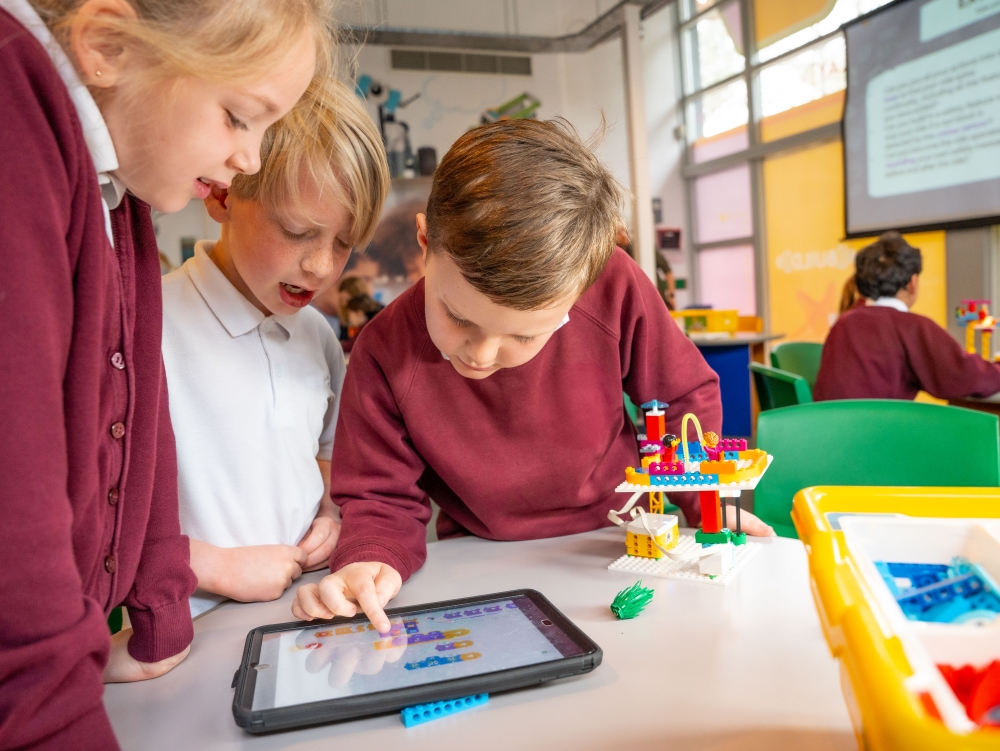 Primary school pupils using a tablet in a LEGOLAND Windsor workshop