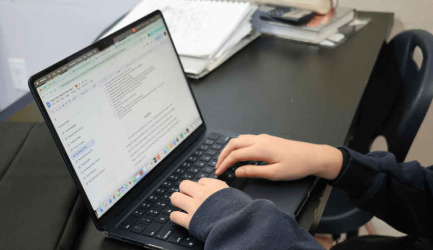 Teacher typing on laptop, representing SEND assessment tools